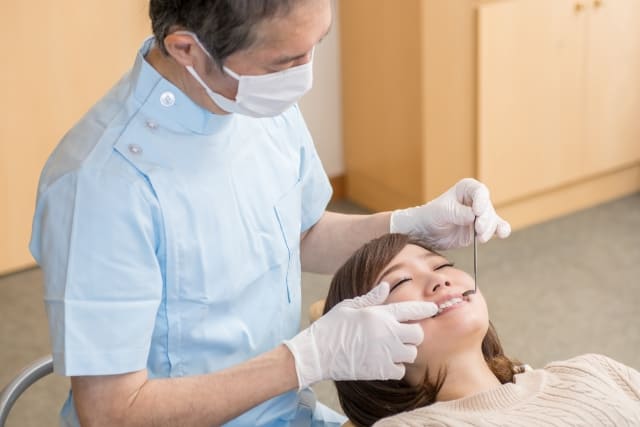 歯医者で施術を受ける女性